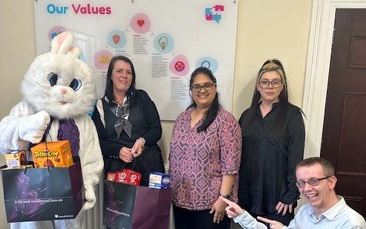 Donations of Easter eggs being made to a person inside a giant bunny rabbit costume.