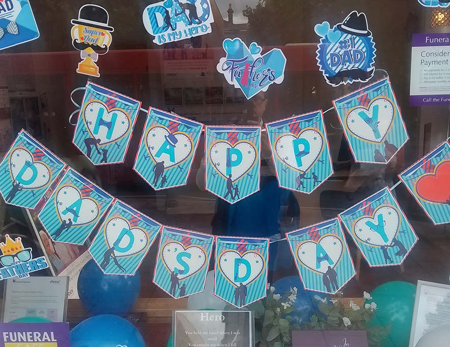 A decorated branch window with a fathers day banner.